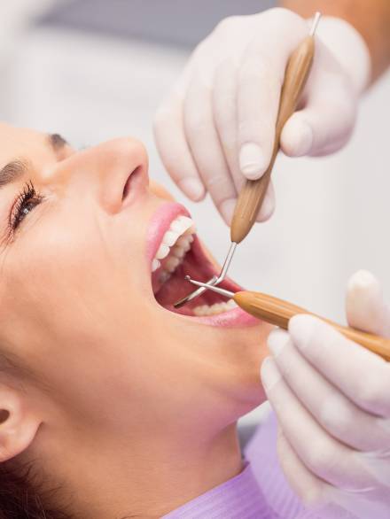 Close up of dentist examining female patient teeth